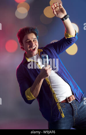 Mann singt ins Mikrofon und tanzt Stockfoto