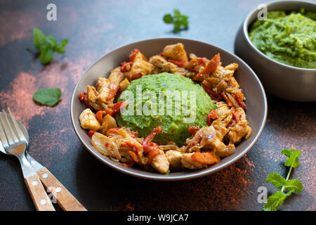Kartoffelpüree mit grünen Erbsen und Mais serviert mit Hähnchen und Gemüse Eintopf. Afrikanische Küche, kenianische Küche, ein traditionelles Gericht namens mukimo Stockfoto