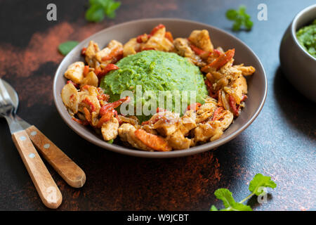 Kartoffelpüree mit grünen Erbsen und Mais serviert mit Hähnchen und Gemüse Eintopf. Afrikanische Küche, kenianische Küche, ein traditionelles Gericht namens mukimo Stockfoto