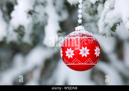 Eine Weihnachtskugel verschneitem Ast Stockfoto