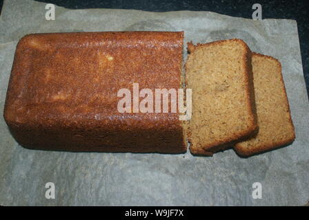 Ein Laib Brot frisch gebackene Banane in Scheiben geschnitten auf ein Backpapier. Stockfoto