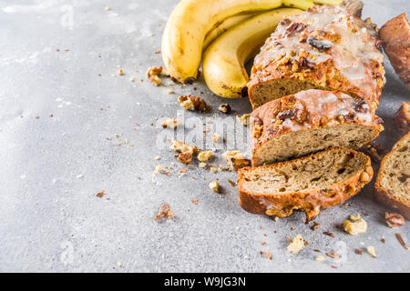 Selbstgemachte Banane Brot mit Nüssen, grauen Stein konkreten Hintergrund Kopie Raum, veganes Essen. Stockfoto