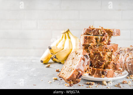 Selbstgemachte Banane Brot mit Nüssen, grauen Stein konkreten Hintergrund Kopie Raum, veganes Essen. Stockfoto