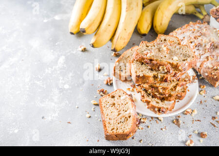 Selbstgemachte Banane Brot mit Nüssen, grauen Stein konkreten Hintergrund Kopie Raum, veganes Essen. Stockfoto