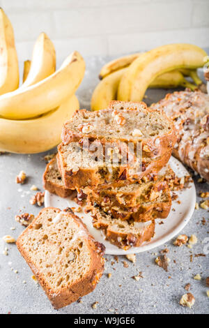 Selbstgemachte Banane Brot mit Nüssen, grauen Stein konkreten Hintergrund Kopie Raum, veganes Essen. Stockfoto