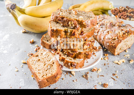 Selbstgemachte Banane Brot mit Nüssen, grauen Stein konkreten Hintergrund Kopie Raum, veganes Essen. Stockfoto