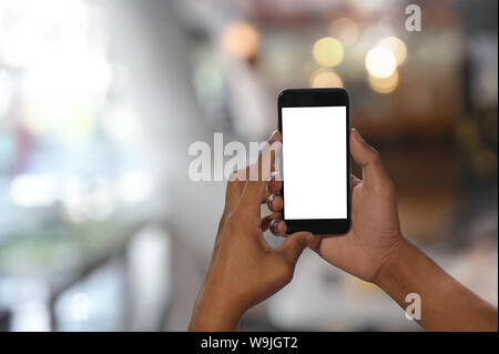 7/8 shot Hände des Menschen mit mockup Smartphone im Hintergrund mit. Stockfoto