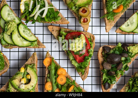 Vegetarische Sandwiches mit Guacamole und Gemüse auf einem Raster Stockfoto