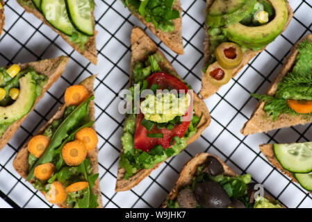 Vegetarische Sandwiches mit Guacamole und Gemüse auf einem Raster Stockfoto