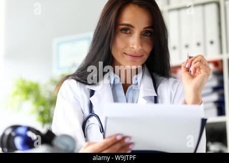 Ziemlich weiblich GP am Arbeitstisch Notizen zu machen Stockfoto