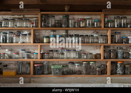 Zeilen aus recyceltem Glas Gläser verwendeten Behälter verschiedener Größe zu speichern, Schrauben, Nägel, Boote, Unterlegscheiben, Muttern in einer organisierten Weise Stockfoto