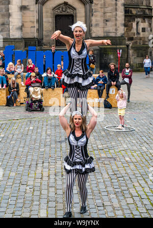 Edinburgh, Schottland, Großbritannien, 14. August 2019. Edinburgh Festival Fringe: Festivalbesucher watch Darsteller und Straßenunterhaltung an der Royal Mile. Diese weiblichen australischen akrobatische Darsteller sind die Zimmermädchen genannt Stockfoto