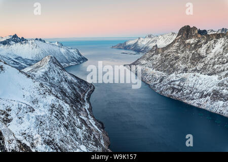 Blick von oben auf die schneebedeckten Gipfel der Umgebung Fjordgard durch das gefrorene Meer bei Sonnenuntergang, Ornfjorden, Senja, Troms, Norwegen, Skandinavien, Europa Stockfoto