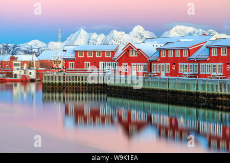 Rosa Sonnenuntergang über die typische rote Häuser spiegelt sich im Meer, Svolvaer, Lofoten-Inseln, Arktis, Norwegen, Skandinavien, Europa Stockfoto