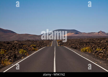 Gerade Straße durch vulkanische Landschaft in die Ferne Stockfoto