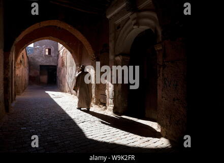 Der Mann, der eine djellaba wirft einen langen Schatten in einer sonnenbeschienenen Straße in der Kasbah, Marrakesch, Marokko, Nordafrika, Afrika Stockfoto