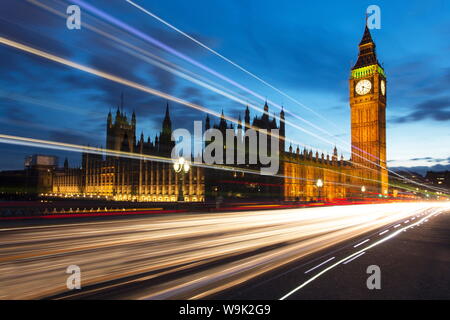 Houses of Parliament und Big Ben bei Nacht mit Flutlicht mit bunten Lichterkette von Durchgangsverkehr auf die Westminster Bridge, London, England, Großbritannien
