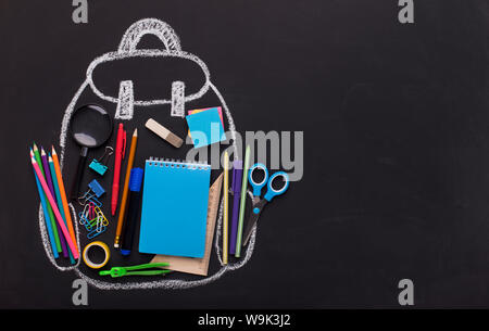 Kreide bemalt Rucksack mit Bürobedarf auf schwarzem Hintergrund Stockfoto