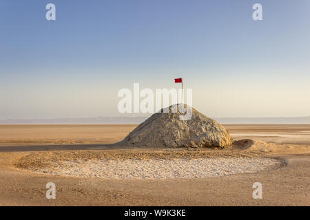 Chott el Djerid, dem größten Salzsee der Sahara in Tunesien und tunesische rote Flagge auf dem Hügel unter dem blauen Himmel Stockfoto