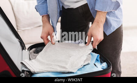 Vorbereitungen für die Reise. Mann Verpackung Kleidung in die Tasche Stockfoto