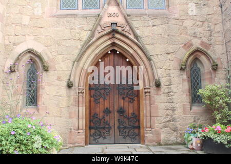 Bild der wunderschön gestalteten Tür der Knutsford methodistische Kirche mit kleinen Pflanzen und Blumen vor der Stockfoto