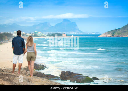 Ein junges Paar mit Blick auf Pontal Strand, Barra da Tijuca und die Pedra da Gavea, Rio de Janeiro, Brasilien, Südamerika Stockfoto