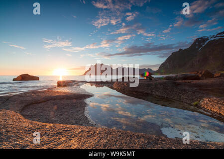 Rosa Wolken und Mitternachtssonne sind im blauen Meer von felsigen Gipfeln umrahmt, Uttakleiv, Lofoten, Norwegen, Skandinavien, Europa wider Stockfoto