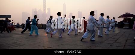 Menschen, die am frühen Morgen t ' ai Chi Übungen im Huangpu Park auf den Bund, Shanghai, China, Asien Stockfoto
