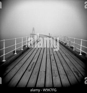 Suchen Holz entlang der Promenade von Whitby Pier am Tag Misty's Winter, Whitby, North Yorkshire, England, Großbritannien Stockfoto