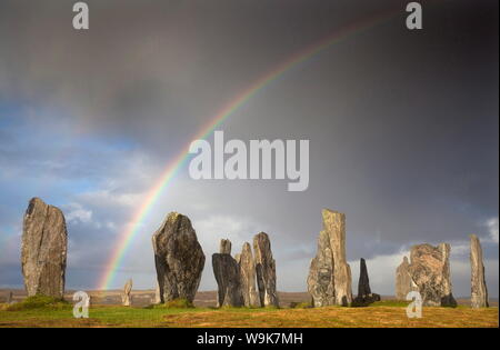 Standing Stones von Callanish im Sonnenlicht mit einem Regenbogen über den Himmel im Hintergrund, auf der Insel Lewis, Äußere Hebriden, UK gebadet Stockfoto