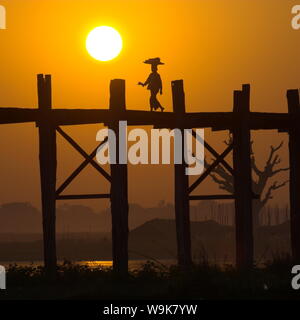 Frau auf U-Bein Brücke am Taungthaman See Silhouette gegen den Sonnenuntergang, Mandalay, Myanmar (Birma), Asien Stockfoto