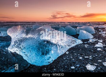 Gebrochenes Eis aus angespülten Eisberge am Jökulsárlón schwarzen Strand bei Sonnenuntergang, Jökulsárlón, südöstlichen Island, Island, Polarregionen Stockfoto