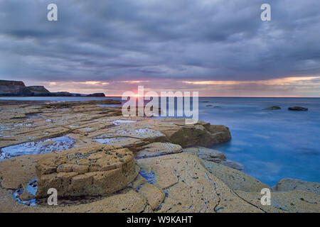 Sonnenuntergang auf einem regnerisch abends gegen Bay, North Yorkshire, Yorkshire, England, Vereinigtes Königreich, Europa Stockfoto