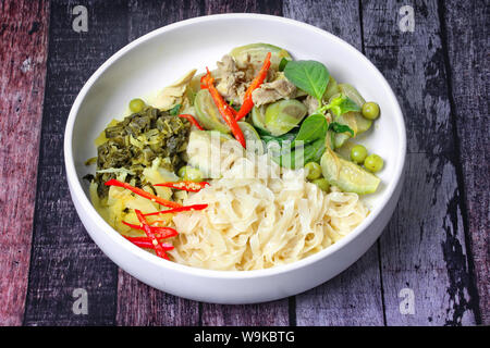 Beliebte Thailändische, chinesische Nudeln mit grünem Chicken Curry mit Kokosmilch nachgefüllt gehackte Essiggurke Kopfsalat. Stockfoto