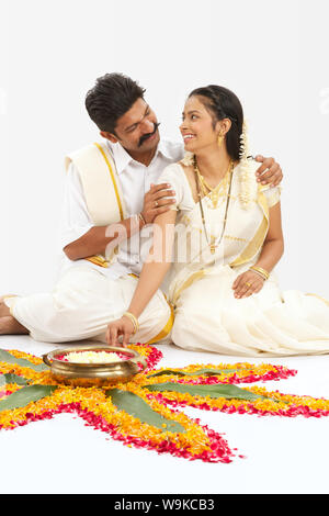 Südindisches Paar, das Rangoli macht Stockfoto