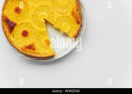 Nach oben Ananas Kuchen auf weißen Tisch geschnitten. Sommer tropischen Dessert. Ansicht von oben. Platz kopieren Stockfoto