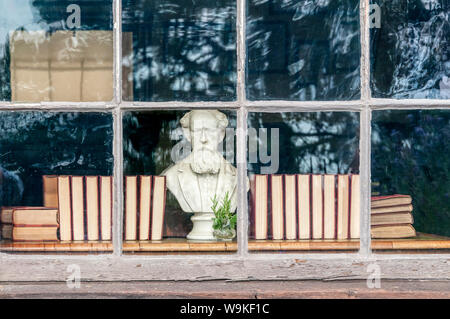 Eine Büste von Charles Dickens schaut aus einem Fenster des Dickens House Museum in Cranbrook, Kent. Stockfoto