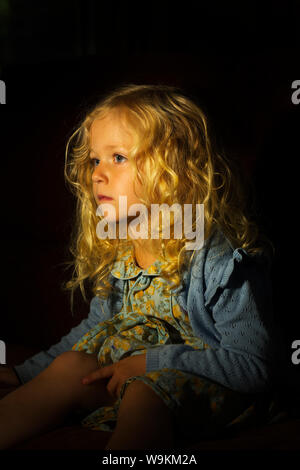 Eine schöne kleine Blonde mit Locken Stockfoto