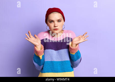 . Junge schwere Frau zum Ausdruck bringt ratlos und verwirrt Emotion mit Armen und hob die Hand. Zweifel Konzept. Ich weiß es nicht. Isolierte blauen Hintergrund, Studio Stockfoto