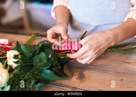 Nahaufnahme 7/8 Foto der weiblichen florist Bündel bilden und binden Ribbon im Flower Shop. Stockfoto