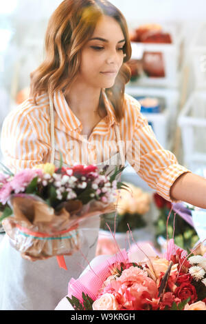 Junge schöne Blumengeschäft blumen Prüfung im Shop hinter einer Glaswand, Job, Beruf, Beruf, bis schließen Foto Stockfoto