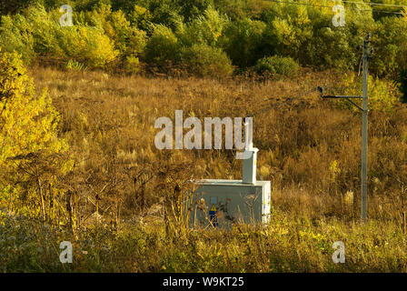Kleine kompakte transformator elektrische Unterstation in einem gelben Feld Herbst Stockfoto