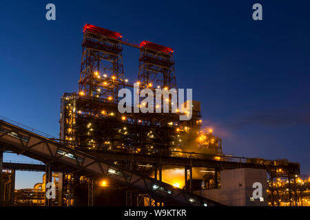 Nacht der industriellen Landschaft mit hellen Lichter der Laternen - 4 - drum Delayed Coking Einheit in einer Erdölraffinerie Stockfoto