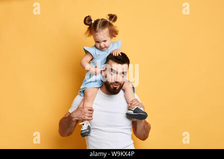 Mädchen ihre Energie verbrennen, während Palying mit Papa. Kind stucking Finger im Ohr von ihrem Vater. Stockfoto