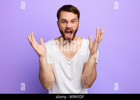Lustiger Mann mit erhobenen Händen an jemand schreien, schreien. Mann, ein Lied singen, isolierte blauen Hintergrund. studio Shot Stockfoto