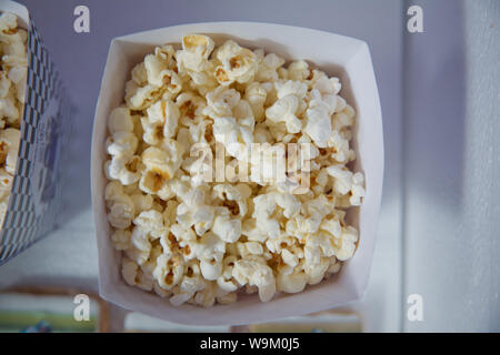 Eine große klassische Feld des Theaters popcorn isoliert auf Weiss. Popcorn verschüttet aus einem gestreiften Box. Drei vintage Stil Boxen von Popcorn in einem Karneval Sie Stockfoto