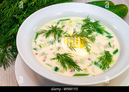 Okroshka die Suppe in einem Teller mit frischen Kräutern Stockfoto