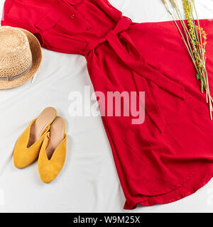 Komfortabel gelbe Sandalen mit Rot trendy Kleid und Strohhut. Sommer Stimmung. top View 7/8-Foto Stockfoto