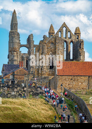 Whitby Abbey mit Stufen vom Stadtzentrum und viele Touristen. Stockfoto