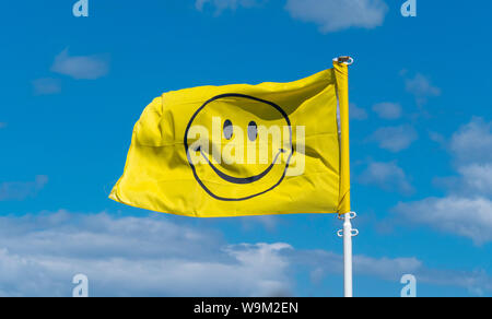 Smiley Symbol auf gelbe Flagge gegen den blauen Himmel Stockfoto